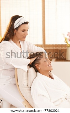 Happy woman enjoying head massage with closed eyes, smiling.?