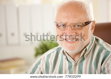 Closeup portrait of elderly man wearing glasses, smiling at camera.?