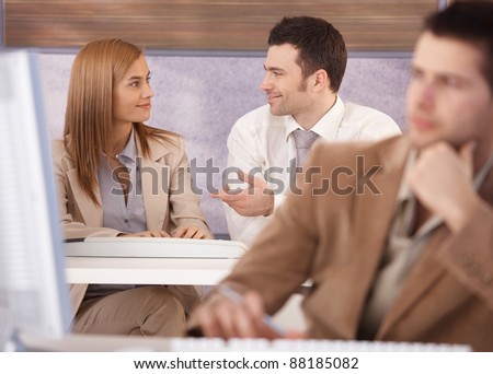 Attractive young woman and man chatting at computer course.?