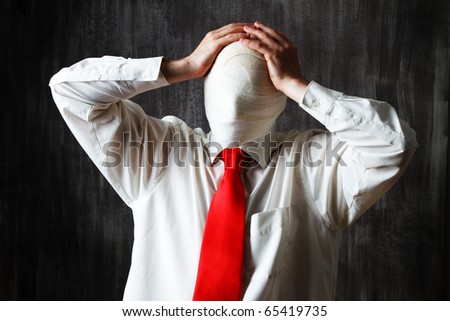 Half body portrait of businessman with face obscured by bandages, dark background.
