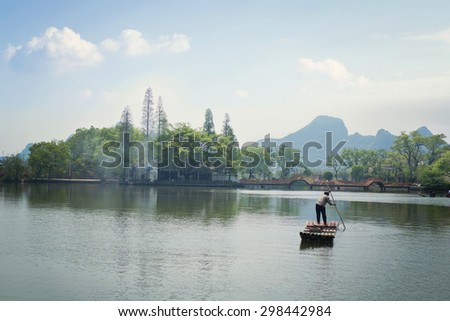 GUILIN CHINA - APR 03: The old lady paddling her boat on the west bank of the Li Jiang River. Taken on Apr 03, 2015, Guilin, China