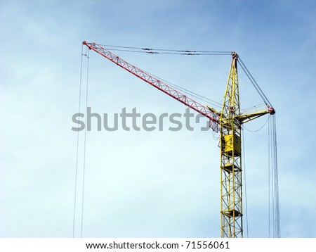 Silhouette of lifting crane against a background of blue sky