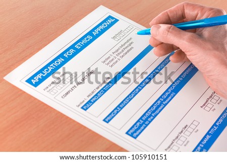 Hand with Pen Writing on Ethics Approval Application Form for a Research Project