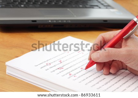 Hand with Pen Proofreading a Manuscript - undiscernable text so can be any Language