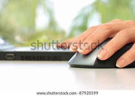 Hands Working on Laptop Computer and Mouse