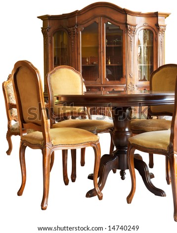 Old classic wooden furniture - a bookshelf, a table and chairs, all with handmade woodcarvings, isolated