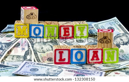 Cold hard cash and wood blocks spelling money loan