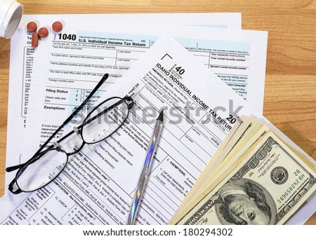 Idaho and federal tax forms with money and medicine