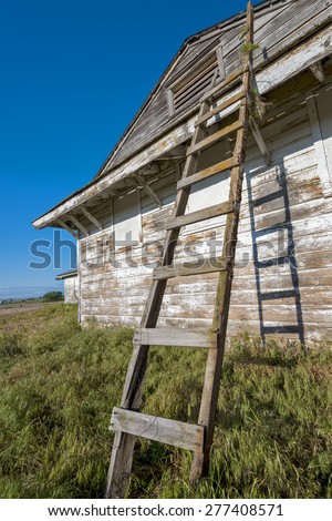 Old country building with peeling pain and ladder