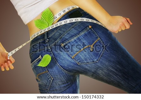 woman in jeans measuring yourself tape and loses weight