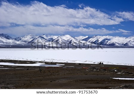beautiful lake view covered by heavy snow with blue sky and white cloud in tibet China