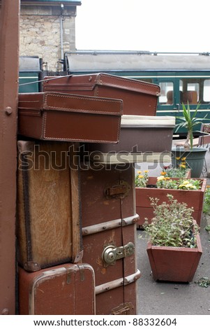 Old suitcases on a wooden trolley at a train station