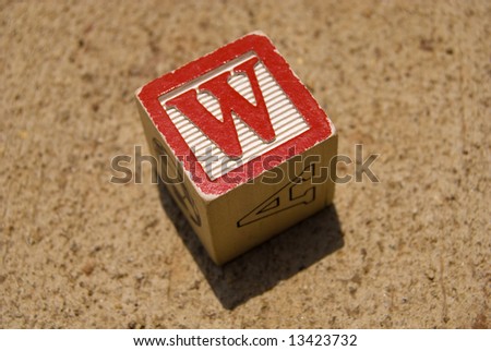 Wooden toy cube with red letter \