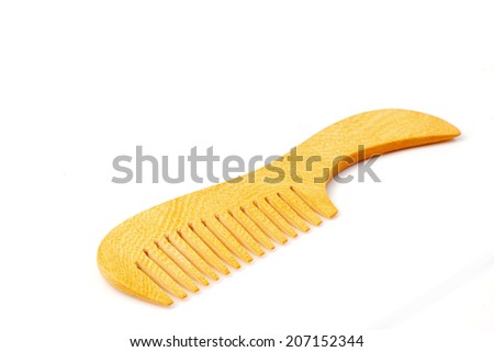 Wooden comb brush isolated over white background.