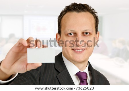 Successful businessman or business trainer holds a business card.