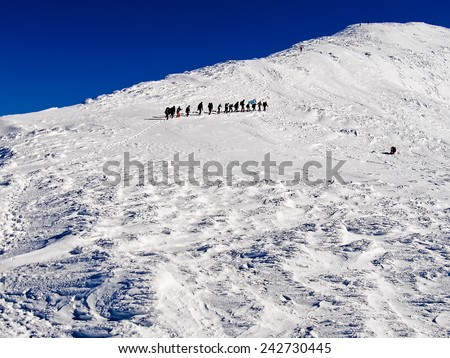 Group of climbers rises by the snow-covered mountain