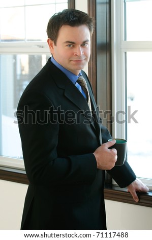 Single man in  business attire standing at a window