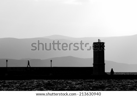 Walking away from the light, Silhouette of man and pair in a hug around the lighthouse, no recognizable person