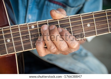 hands of the old man hold guitar