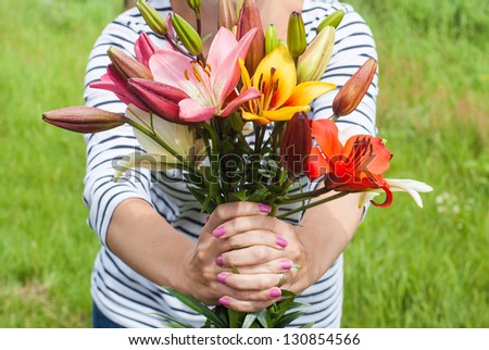 Beautiful lily bouquet holding by a woman in summer