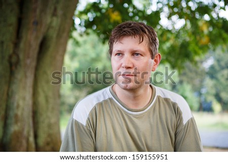 Beautiful young man dreaming in summer garden