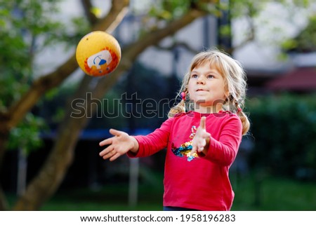 Similar – Image, Stock Photo A little girl catches soap bubbles in the park, sitting on the grass. The concept of a happy childhood