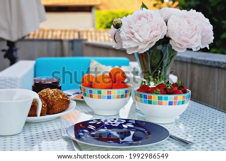 Breakfast table with bread, fresh fruits and strawberries and coffee served on balkony terrace or hotel on summer morning for romantic couple lunch. Zdjęcia stock © 