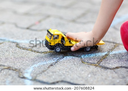 Little child playing with car toy. Selective focus on hand of boy and toy