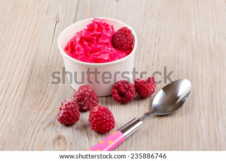 Serving of frozen creamy ice yoghurt  with whole fresh raspberries and vintage old spoon, Healthy bio organic vegan dessert.