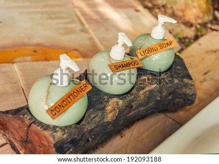 Shampoo, conditioner and liquid soap in a wooden stand