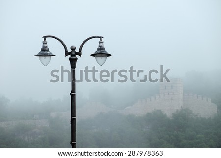 Street lamp and castle wall in fog in Bulgaria