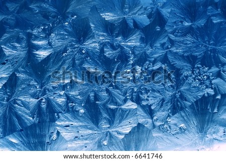 jack frost winter ice patterns on window with a blue twist