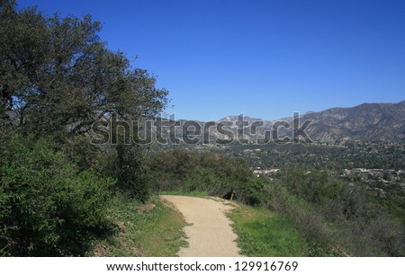 Trail along a hill side with mountains in the distance, California