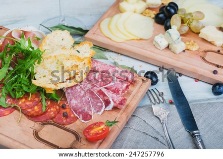 Traditional italian antipasto with prosciutto and different sorts sausage on a wooden table
