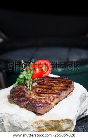 stages of cooking steak on the grill - ready piece of grilled steak with a grill in the background