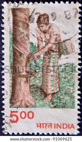 INDIA - CIRCA 1980: A stamp printed in India dedicated to crafts, shows a Women collecting rubber from a tree, circa 1980