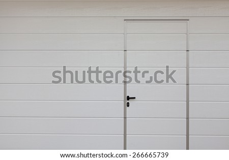 Modern garage door. Large automatic up and over garage door with inclusion of smaller personal door.