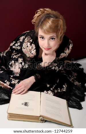pretty young lady  in old time (XIX century)  dress reading book published in  XIX century