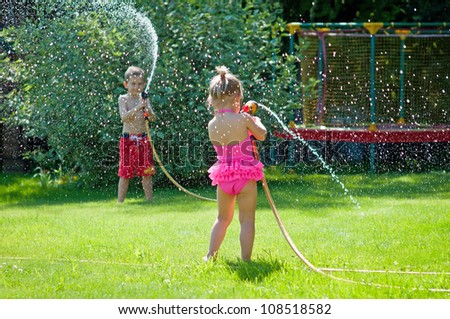 Kids Playing With Water On A Warm Summerday In The Garden Stock Photo ...