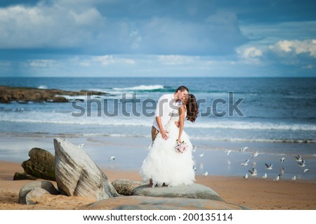 Gorgeous bride in a wedding dress and a handsome groom getting married at a beautiful beach