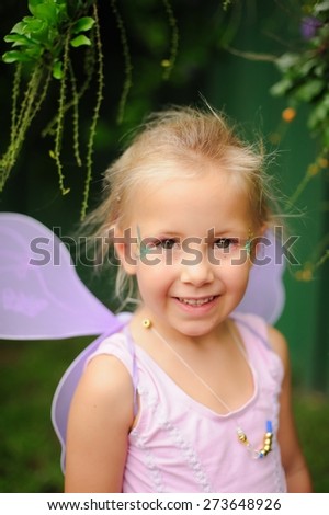 Portrait of a happy child, cute adorable little girl in a fairy costume with fairy wings on her birthday