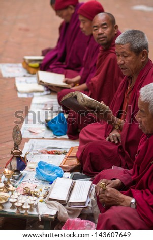 KATHMANDU-APRIL 21: Unidentified group of monks praying at the famous Bouddanath temple in Kathmandu, which is one of the holiest Buddhist sites in Kathmandu, April 21, 2013, Kathmandu, Nepal