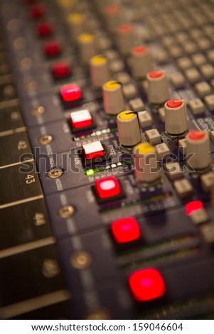 Audio mixer mixing board fader and knobs at night during a live concert