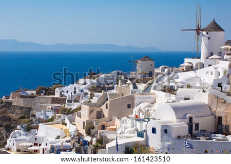 The Windmill in Oia, the latest and the best village for sunset on the island of Santorini, Greece. All the houses are white but dring the sunset, it all become orange.