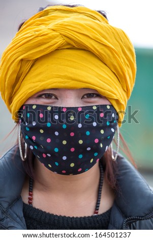 TIBET, CHINA? APRIL 17:  Portrait of an unidentified Tibetan woman wearing a mask and a yellow scarf on the head. Taken on the Friendship Highway. China 2013.