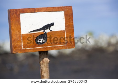 Wooden sign protecting a closed area during nesting near the coast of Isabela island in order to preserve the iguanas population. Galapagos Islands. Ecuador 2015