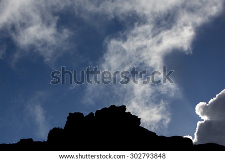 The silhouette of the cliffs of Kukenan tepui or Mount Roraima  with clouds and blue sky. Gran Sabana. Venezuela 2015.