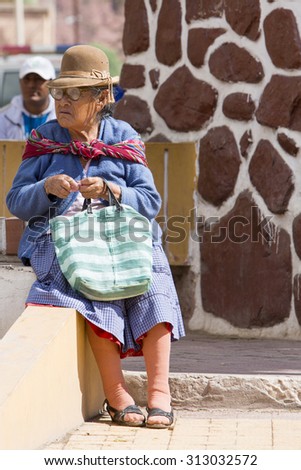 TUPIZA, BOLIVIA, DECEMBER 29: Unidentified senior woman sitting on a bench during the Saturday market of Tupiza. Typical lifestyle of the Altiplano in Bolivia 2014