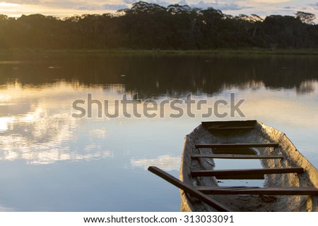 Dramatic sunset in the Amazon rain forest Madidi National Park with a lake and one canoe in the foreground. Rurrenabaque. Bolivia 2015