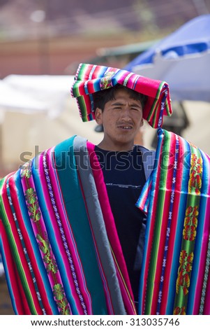 TUPIZA, BOLIVIA, DECEMBER 28: Vendor carrying traditional Bolivian fabrics, rugs and souvenirs during the Saturday town market of Tupiza, Bolivia 2014.